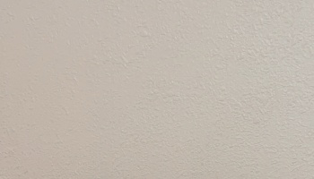 Light beige painted wall with a subtle textured plaster surface.