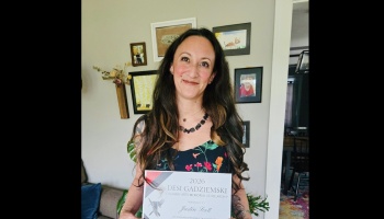 A smiling woman holding a Desi Gadziemski Culinary Arts Memorial Scholarship certificate.