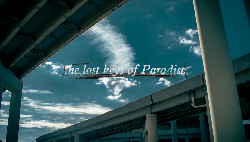 Text reading "the lost keys of Paradise" over a blue, cloudy sky framed by concrete highway overpasses.