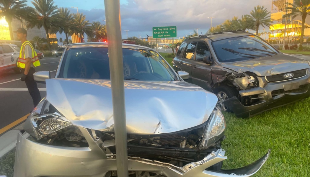 A silver sedan with severe front-end damage crashed into a metal pole alongside a damaged gray SUV.