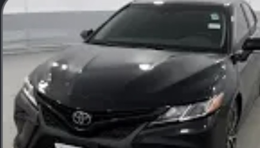 Front view of a sleek black Toyota sedan with tinted windows.