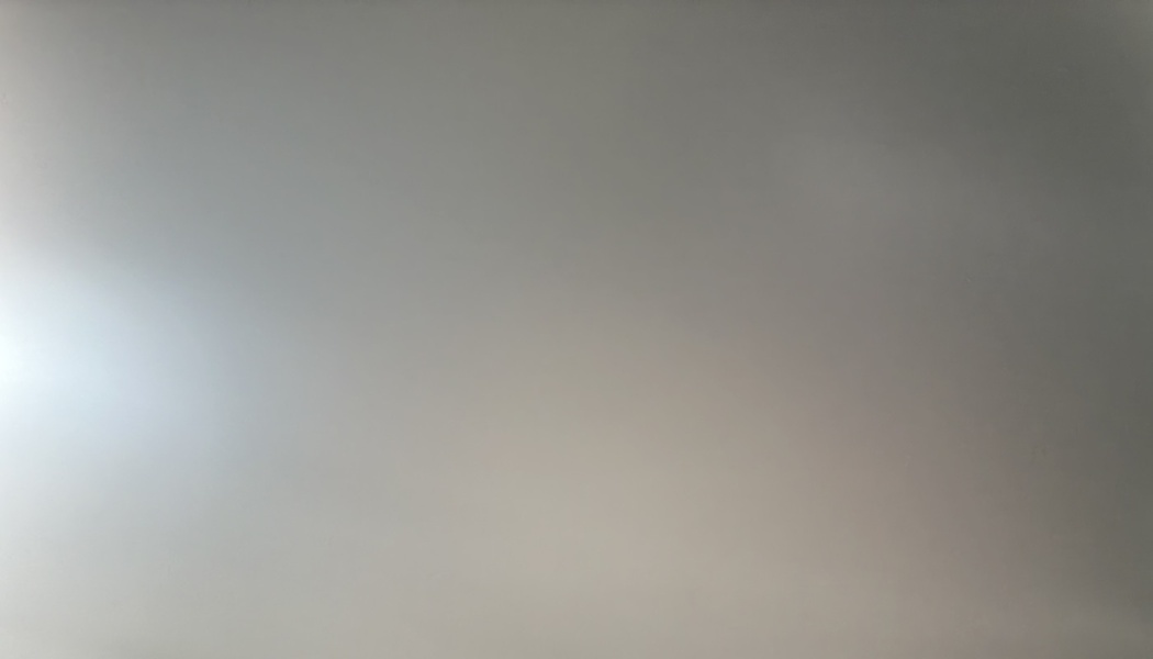 A smooth neutral gray surface with a soft light glare on the left side.