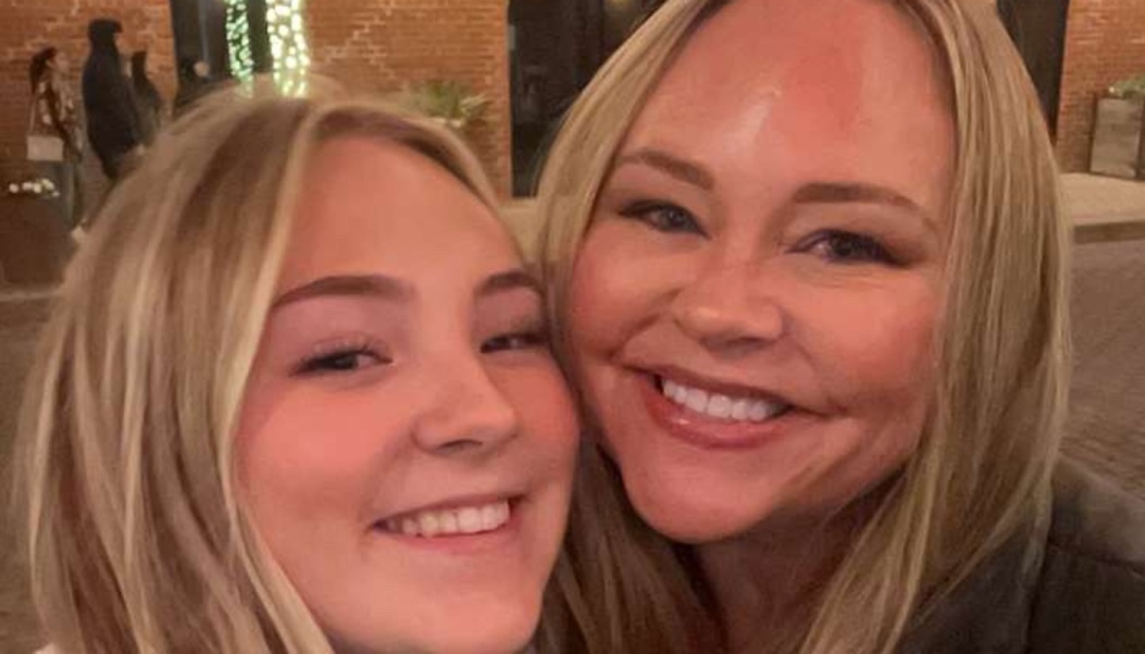 Two blonde women smiling brightly as they pose cheek-to-cheek for a close-up selfie.