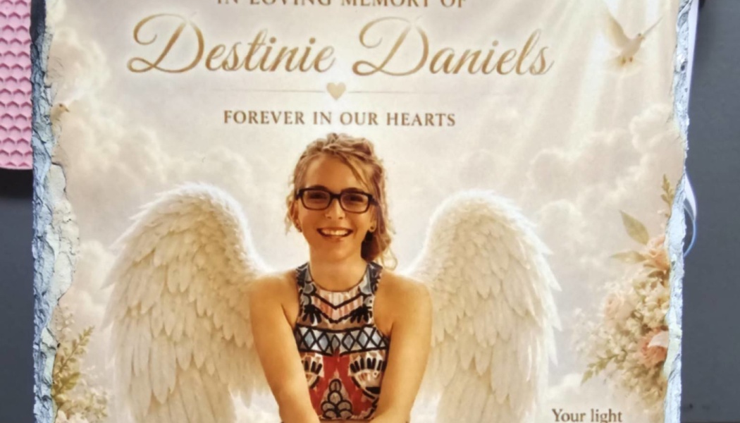 Memorial plaque for Destinie Daniels featuring a smiling young woman with glasses and large white angel wings.