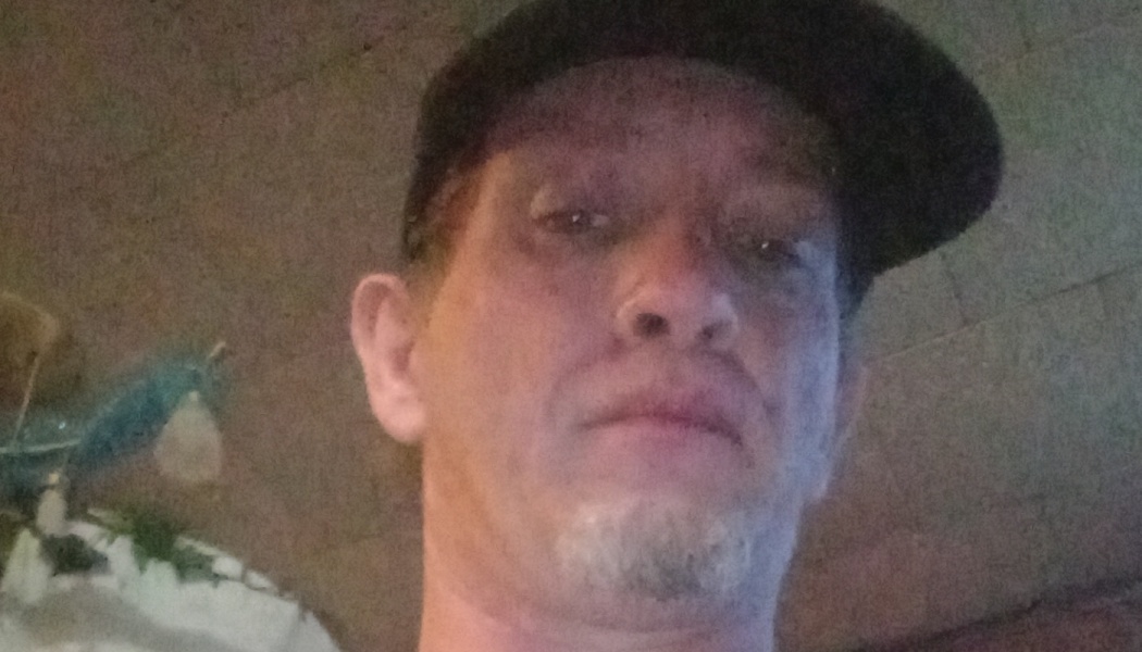 Close-up portrait of a man wearing a dark cap and goatee.