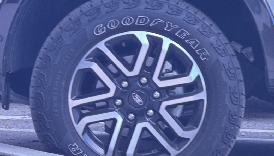 Close-up of a Goodyear all-terrain tire on a Ford vehicle with silver and black alloy rims.