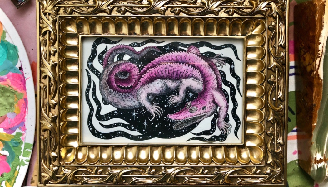An ornate gold frame displaying a pink cosmic alligator illustration against a starry backdrop.