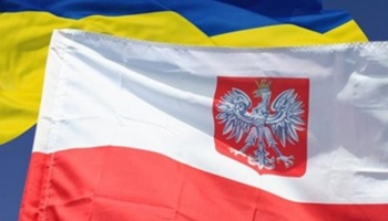 The flag of Poland with coat of arms waving in front of the Ukrainian flag.