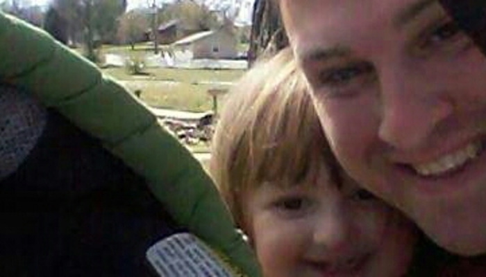 Close-up selfie of a smiling man and a happy young child outdoors.