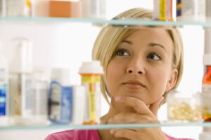 woman medicine cabinet drugs labels
