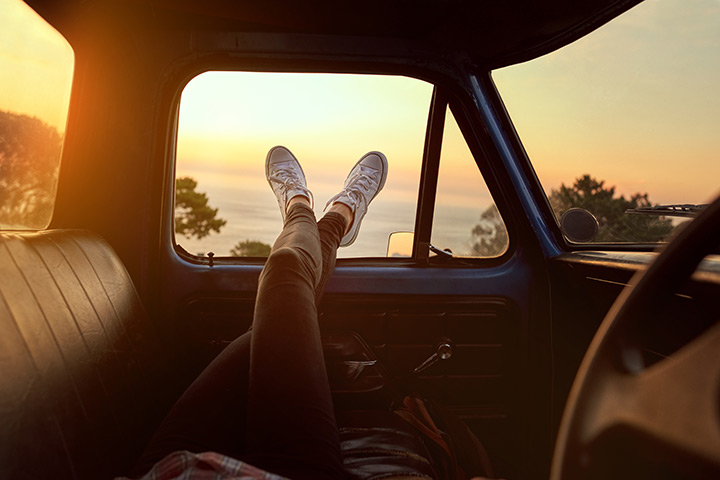 Person sitting in a car overlooking the ocean