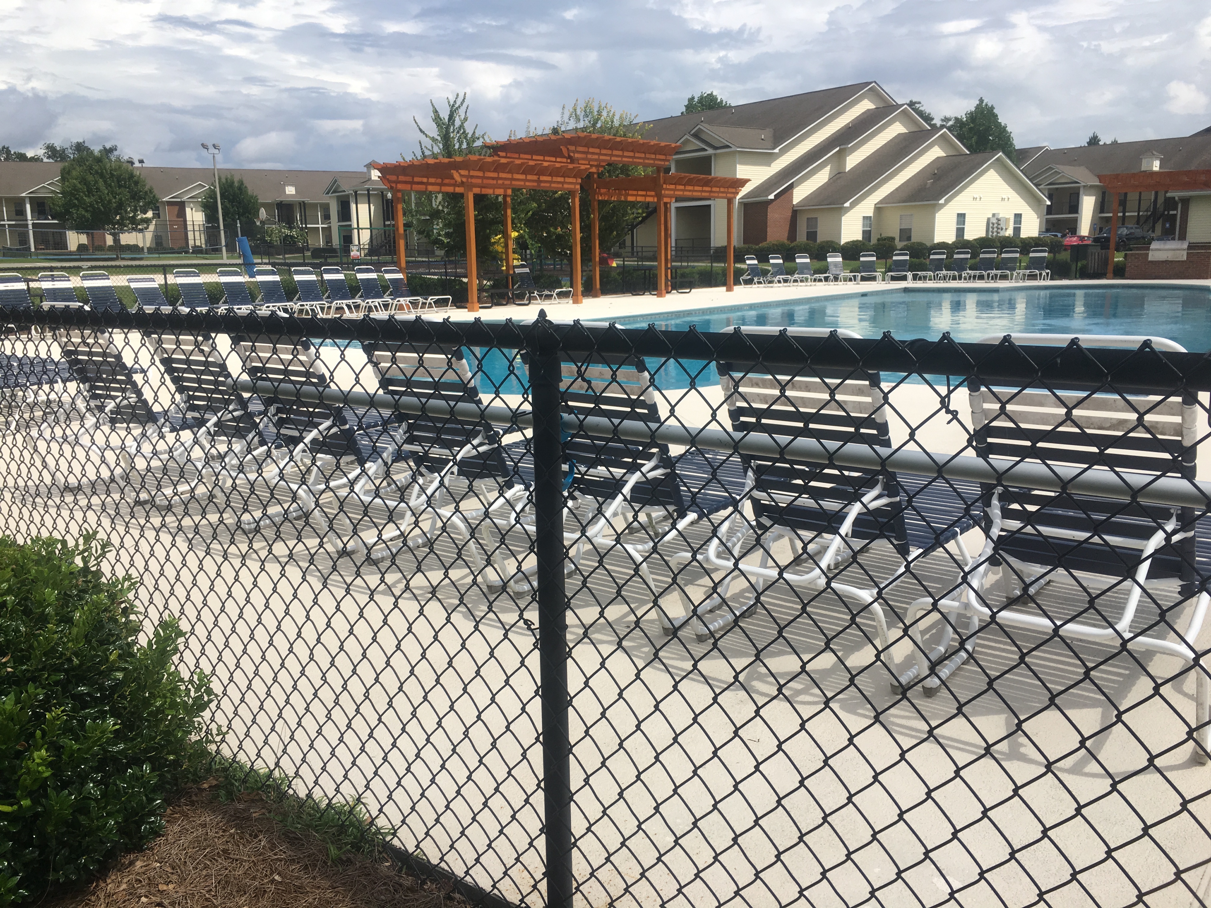 View of the swimming pool as well as the children's playground from the covered lounge area outside the clubhouse at Northwind Apartments luxury apartments on a beautiful day!
