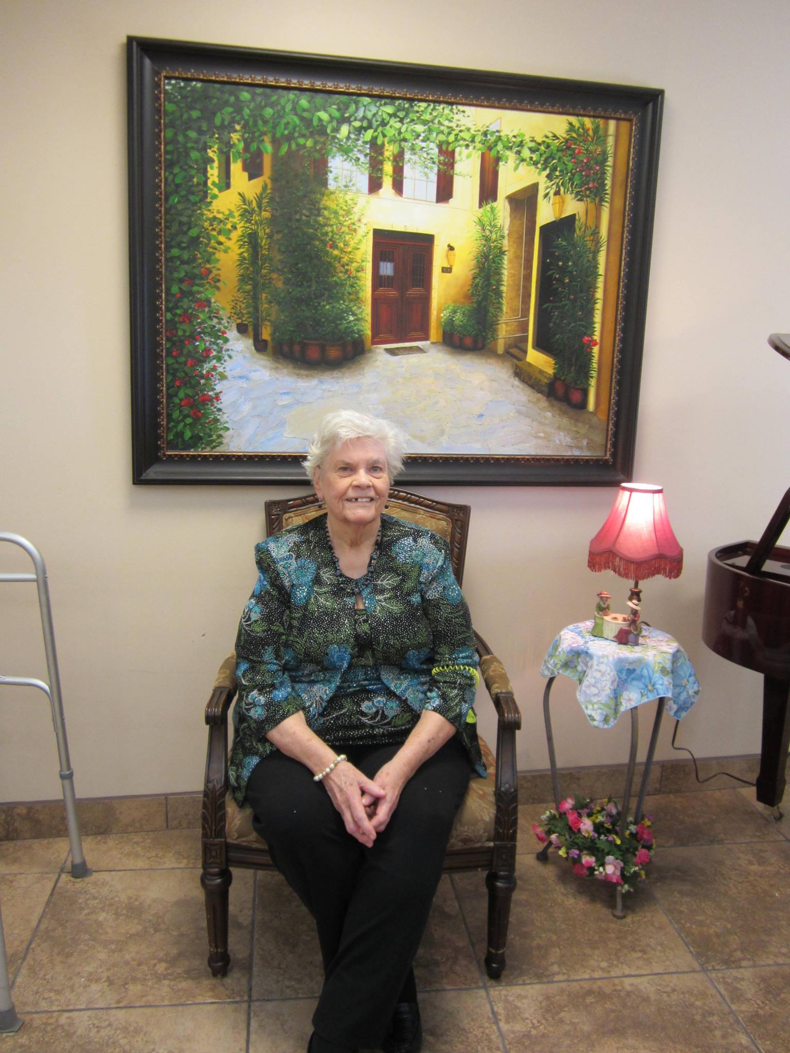 A lady resident sits and smiles at Pennington Gardens