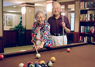 Couple playing pool at senior living in San Jose