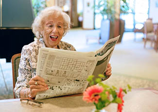 Woman reading the paper at Merrill Gardens at Bankers Hill