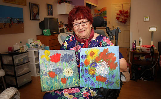 Woman showing her paintings at Carriage Court of Hilliard in Hilliard