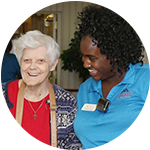 A resident and caregiver laugh together at Carriage Court of Hilliard in Hilliard
