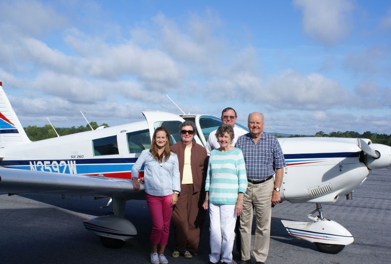 elder people posing in front of plane in activity at The Foothills Presbyterian Community in Easley, SC
