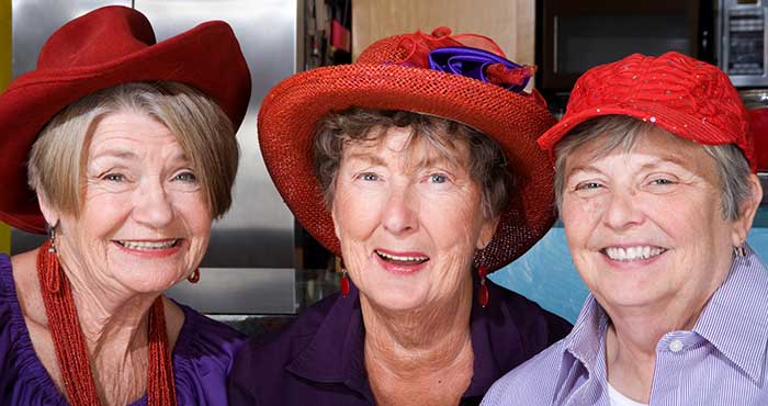 Three happy ladies in their red and glamorous hats at The Foothills Presbyterian Community
