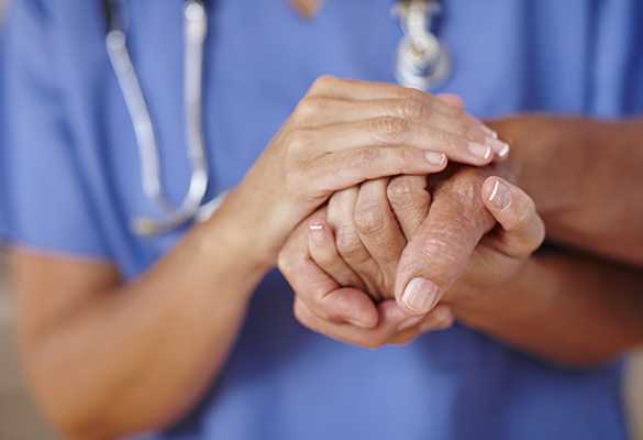 Caretaker holds a resident's hand at Pacifica Senior Living Peoria