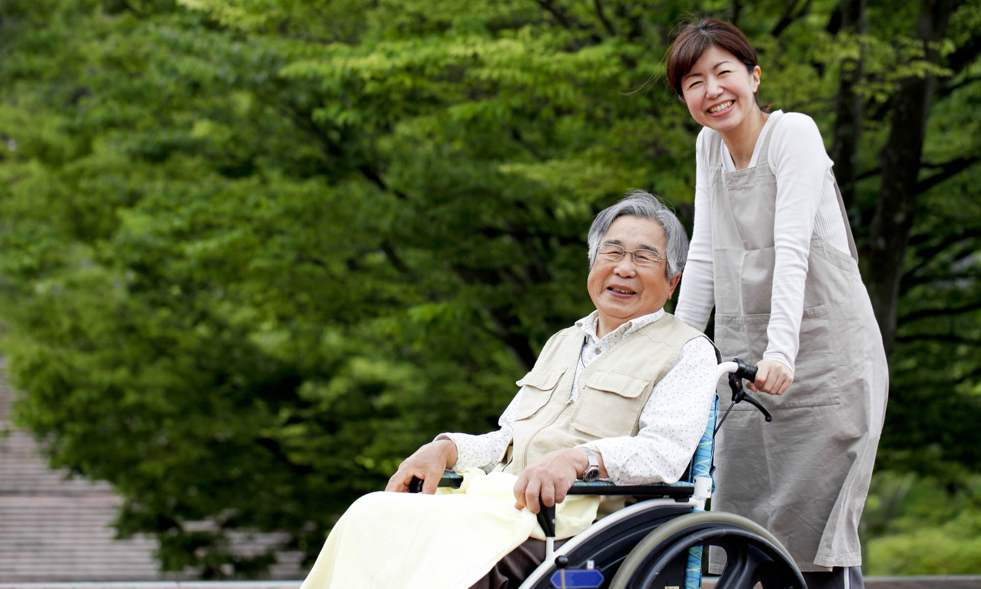 Senior and caregiver enjoy a sunny day at Sakura Gardens