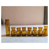 Eight Amber Glass Bottles in Varying Sizes