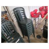 Eight green stacking patio chairs