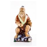 Ceramic Figurine of Seated Man in Traditional Dres