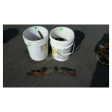 Two buckets of axe and pick axe heads