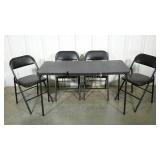 Folding table and four chairs. Table has notch