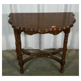 Small foyer stand with scalloped edges.