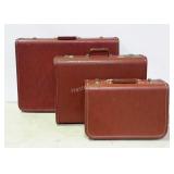 Three vintage suitcases, two are matched pair by