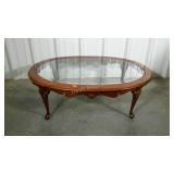 Glass top oval coffee table. Shows wear.