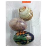 Two marble eggs and a wooden egg
