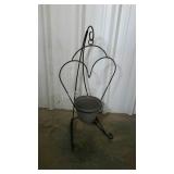 Wrought iron hanging planter with plastic pot.