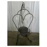 Wrought iron hanging planter with plastic pot.