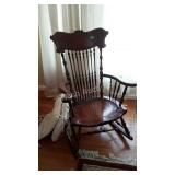 Pressed back rocking chair with turned spindles.