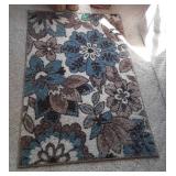 Home Decor scatter rug, wicker wastebasket, and