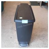 Black plastic trashcan with foot pedal to lift