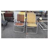 Four lawn chairs, three are webbed one is wooden