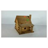 Pine birdhouse in shape of a logcabin.