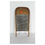 Wood and metal washboard with rounded top.