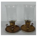 Two brass candlestick holders with glass globes,