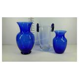 Two blue vases and a clear vase with blue glass