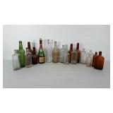 Group of vintage liquor and medicine bottles.