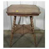 Older lamp table. Turned legs and carved edges.