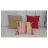 Three complimentary throw pillows in reds and