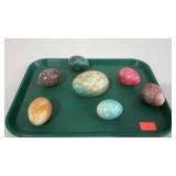 Seven marble eggs in assorted colors. One large
