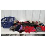 Laundry basket full of hats, scarves and gloves.