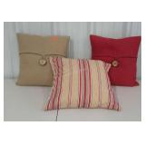 Three complimentary throw pillows in reds and
